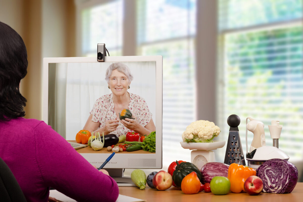 Registered dietitian is educating senior patient on proper nutrition by online. She is choosing vegetables that help treat and prevent diseases aged woman