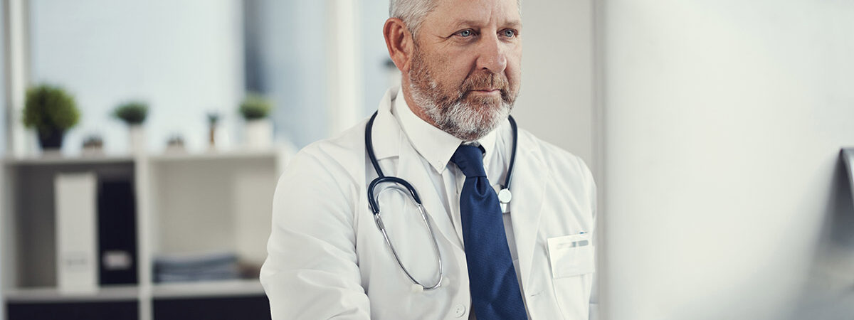 Connected to all things in healthcare Shot of a mature doctor using a computer at a desk in his office